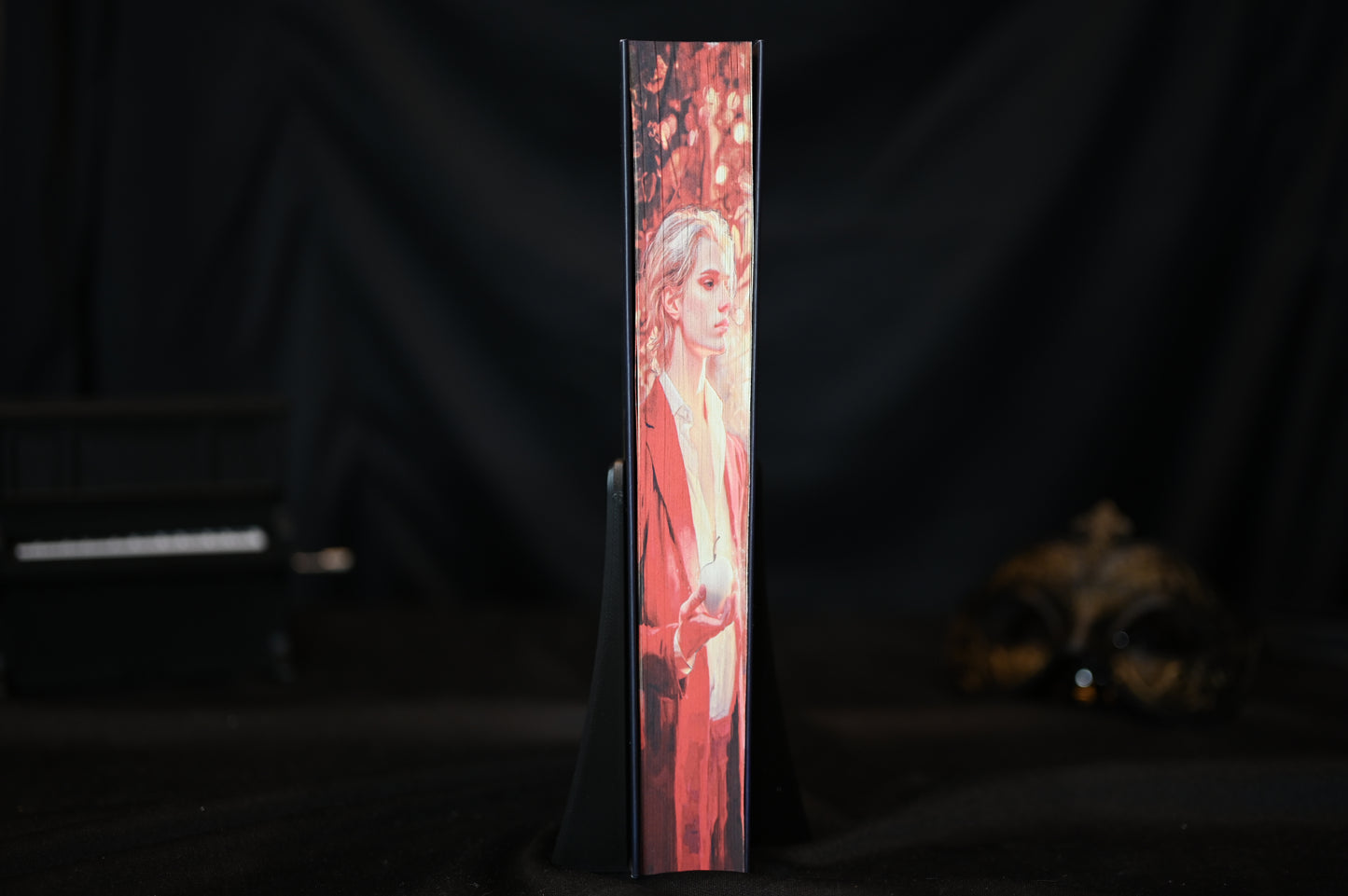 Margine ilustrată a unei cărți din seria A fost odată o inimă frântă, cu portretul unui tânăr blond ținând un măr, pe fundal cu frunziș auriu.