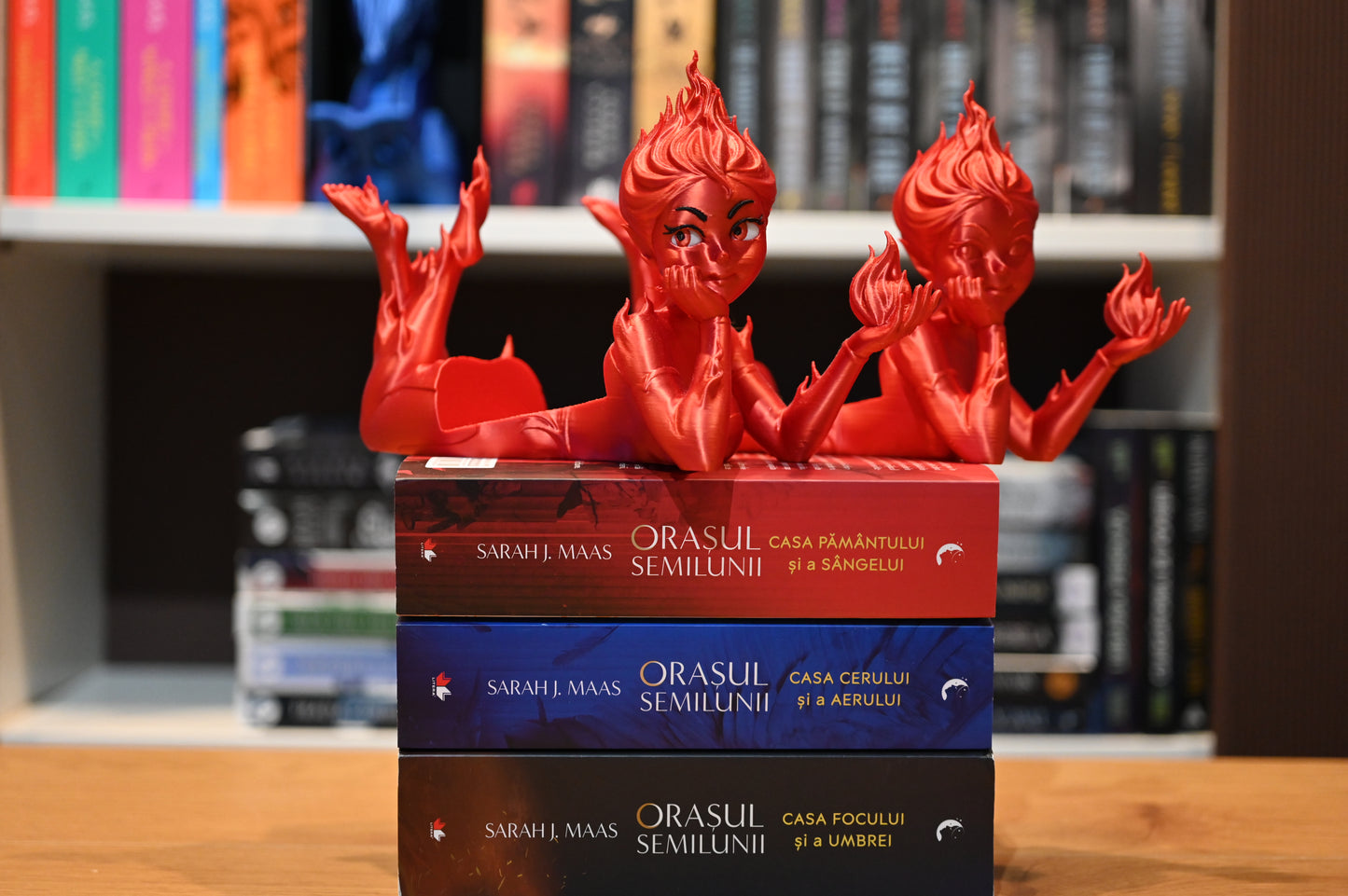 figurine cu femei rosii ce intruchipeaza spiritul focului stand pe seria Orasul Semilunii scrisa de Sarah J Maas