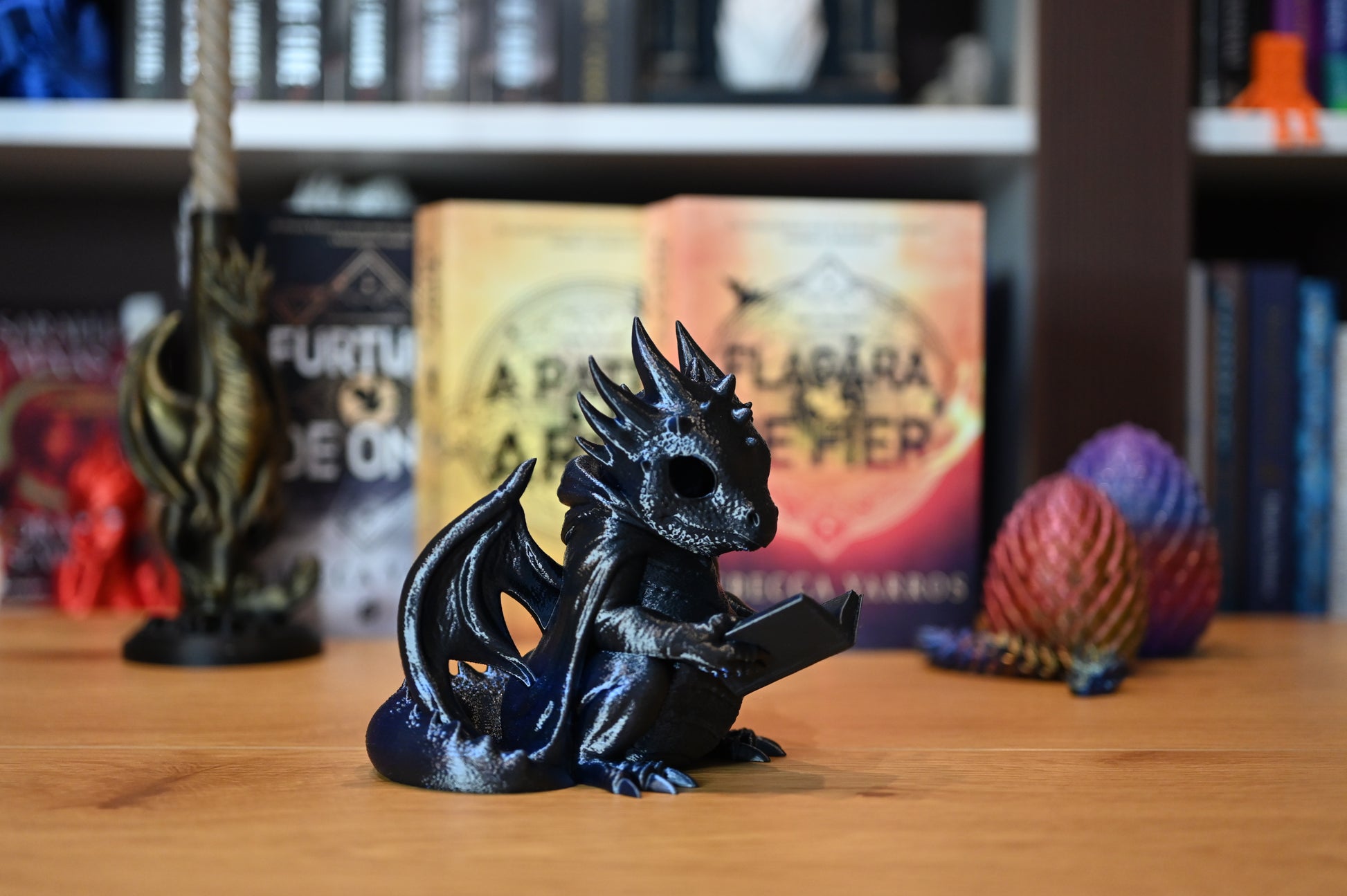 Dragonul Cititor Figurina dragon albastru cu detalii metalice, ținând o carte în labe, decor fantasy pentru bibliotecă sau raft de cărți, perfect pentru iubitorii de lectură și dragoni.