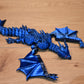 Figurina 3D articulată Figurina dragon albastru metalic articulat, cu ochi violet și detalii realiste, decor fantasy pentru birou sau bibliotecă.