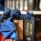 Figurina 3D articulată dragon albastru metalic articulat, imprimat 3D, cu ochi violet și detalii realiste, decor fantasy pentru birou sau bibliotecă.
