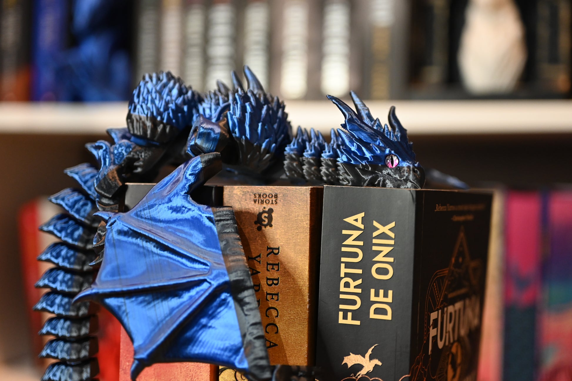 Figurina 3D articulată dragon albastru metalic articulat, imprimat 3D, cu ochi violet și detalii realiste, decor fantasy pentru birou sau bibliotecă.