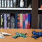 Set de trei dragoni decorativi — alb perlat, verde iridescent și albastru metalic — figuri articulate 3D pentru decor fantasy și colecționari.