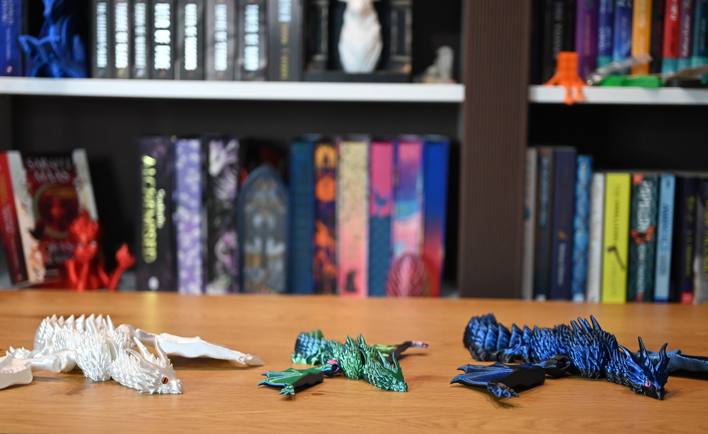 Set de trei dragoni decorativi — alb perlat, verde iridescent și albastru metalic — figuri articulate 3D pentru decor fantasy și colecționari.