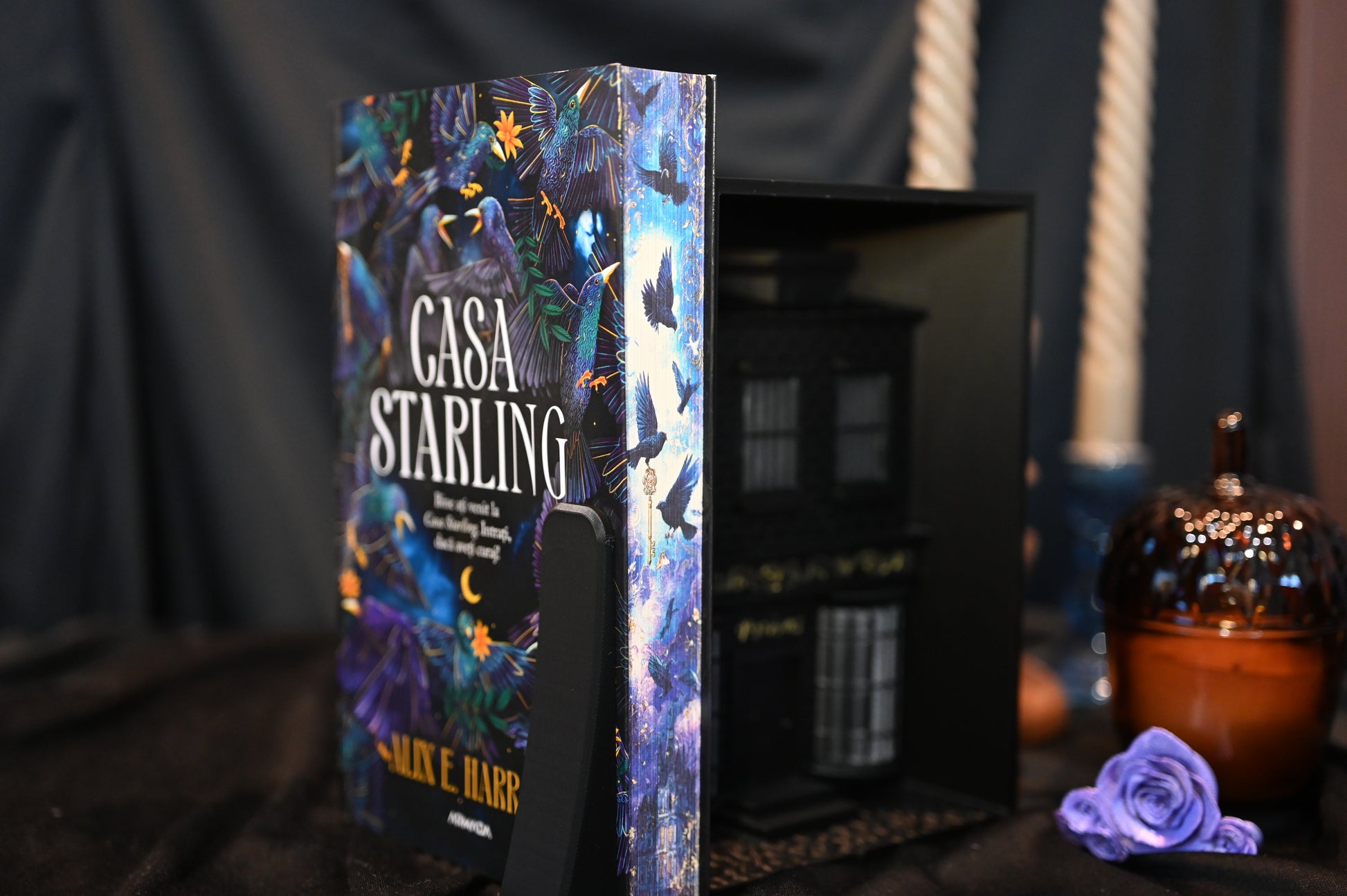 Casa Starling cu printed edges de Alex E. Harrow, ediție specială cu margini imprimate (printed edges) ilustrate cu păsări albastre și fundal nocturn, expusă într-un decor elegant.