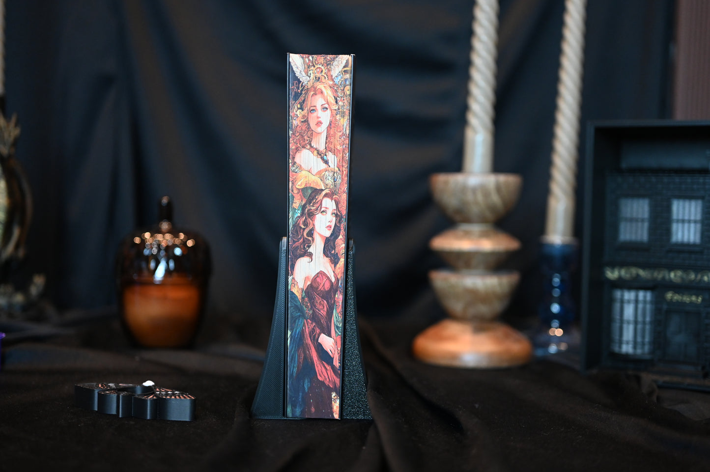 Prim-plan pe latura imprimată a cărții Caraval cu printed edges , prezentând ilustrații detaliate cu personaje feminine în stil victorian-fantasy, lângă decor de raft magic.