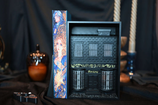 Cartea Legendar cu printed edges de Stephanie Garber, ediție specială cu margini imprimate (printed edges) ilustrate în nuanțe de albastru și auriu, așezată pe fundal negru elegant.