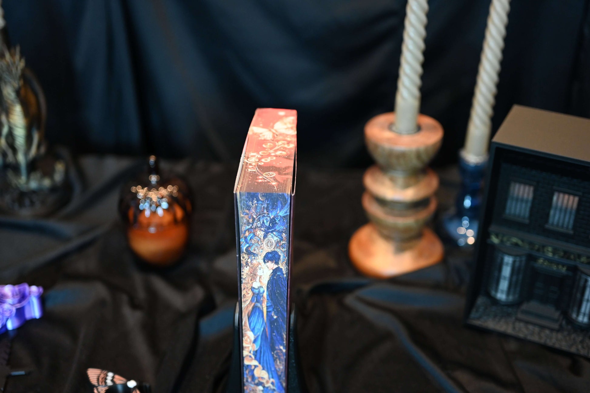 Ediția Finalul de Stephanie Garber, prezentând margini imprimate artistic cu un cuplu elegant în ținute de epocă și fundal fantasy albastru-auriu.