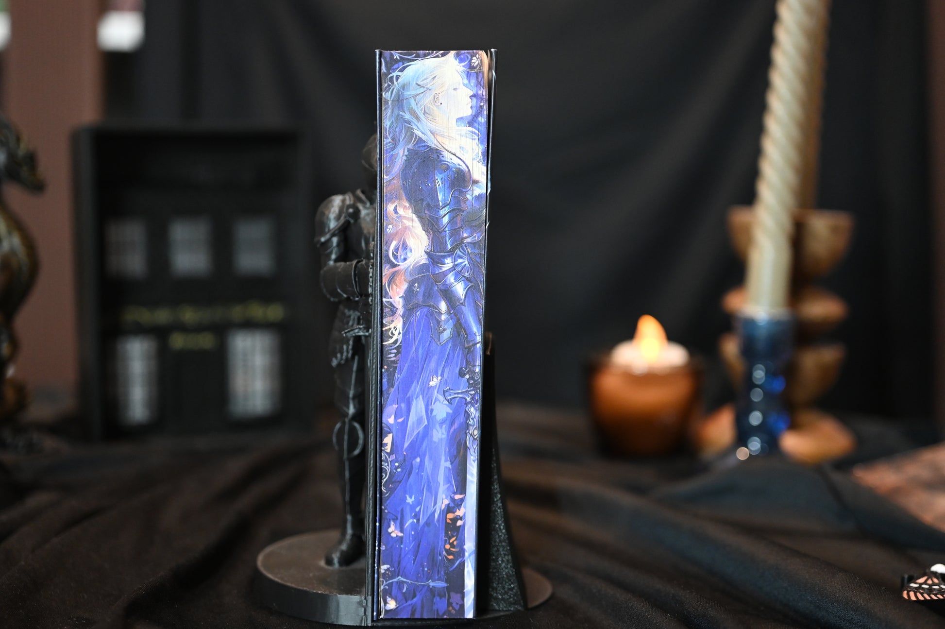 Cavalerul și molia cu printed edges de Rachel Gillig, ediție specială cu printed edges. Coperta prezintă o femeie cu părul auriu și ochii acoperiți, iar pe marginea cărții se vede o ilustrație în nuanțe de albastru cu o siluetă în armură