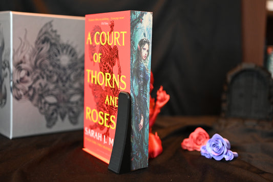 Set Acotar cu printed edges Volumul A Court of Thorns and Roses cu copertă roșie și margini imprimate ce înfățișează o femeie elfă într-un decor mistic de pădure.