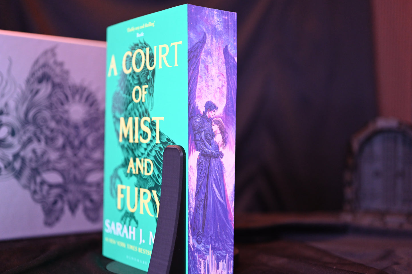 Set Acotar cu printed edges Cartea A Court of Mist and Fury cu margini imprimate, prezentând o scenă romantică între două personaje sub lumina violetă a cerului.