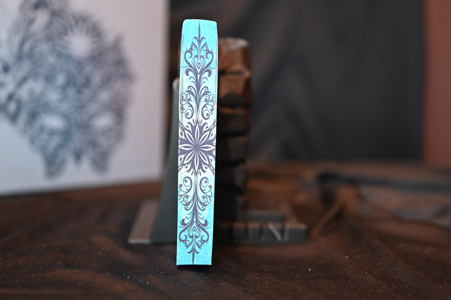 Detaliu al marginii imprimate a volumului A Court of Frost and Starlight, cu model ornamental inspirat de zăpadă și lumina stelelor.