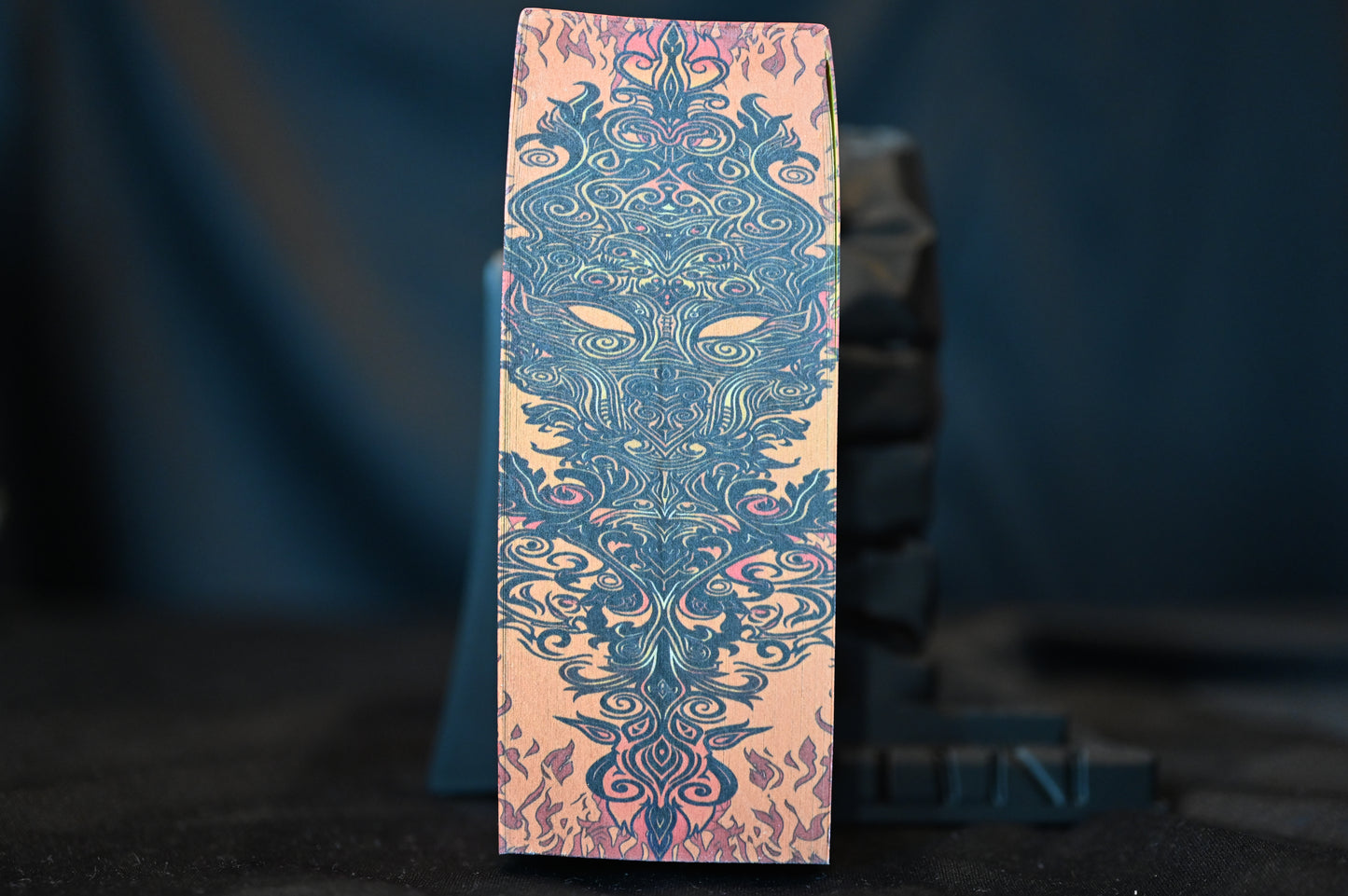 Margine imprimată cu simbol decorativ al flăcărilor și măștii magice, detaliu din ediția A Court of Silver Flames.