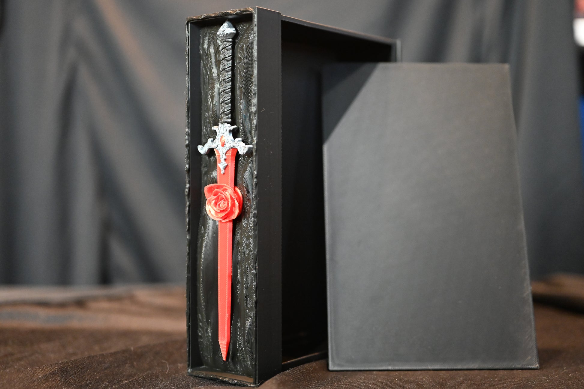 Book nook „The Hidden Rose Sword” de Print Edges – sabie roșie cu trandafir sculptat într-o cutie decorativă neagră.