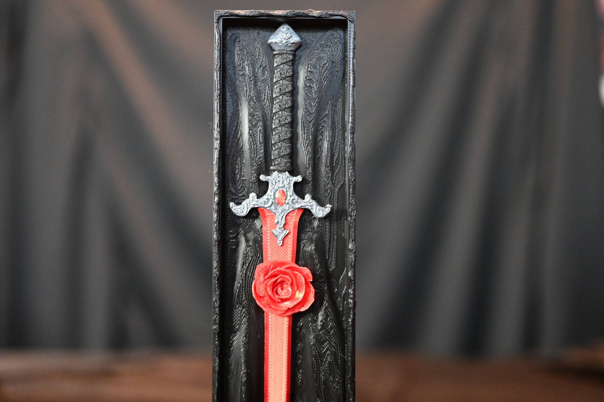 Book nook „The Hidden Rose Sword” de Print Edges – sabie roșie cu trandafir sculptat într-o cutie decorativă neagră.