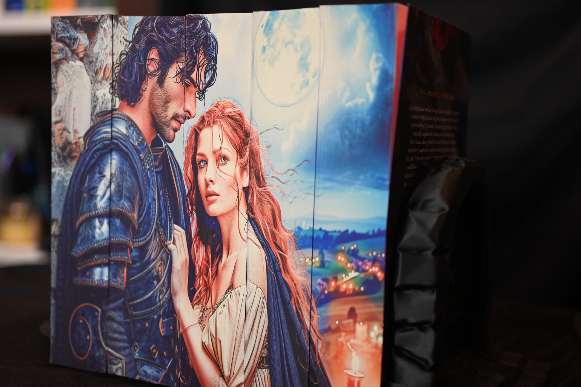 Set Din sânge și cenușă - 5 volume cu printed edges, prezentând o ilustrație detaliată cu un bărbat în armură și o femeie cu păr roșcat și ochi verzi, sub o lună plină, pe un fundal de peisaj nocturn.