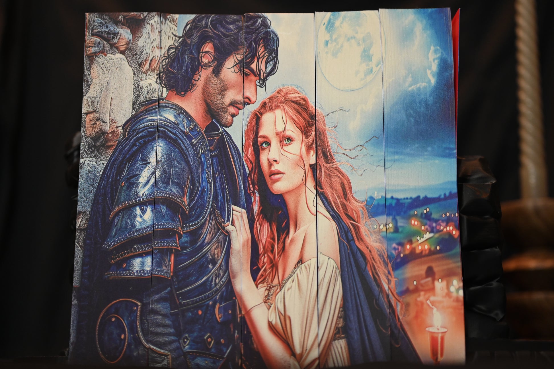 Din sânge și cenușă cu printed edges, prezentând o ilustrație detaliată cu un bărbat în armură și o femeie cu păr roșcat și ochi verzi, sub o lună plină, pe un fundal de peisaj nocturn.