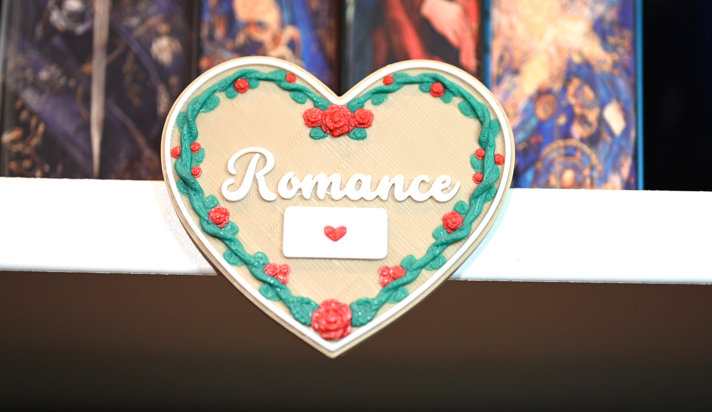 Etichetă 3D în formă de inimă pentru secțiunea Romance, bej cu ramă de trandafiri roșii și viță verde, având un plic alb cu inimioară roșie.