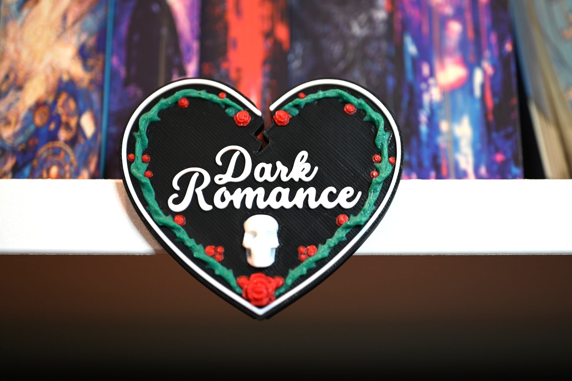 Etichetă 3D în formă de inimă neagră pentru secțiunea Dark Romance, decorată cu trandafiri roșii, viță verde și un mic craniu alb în partea de jos.