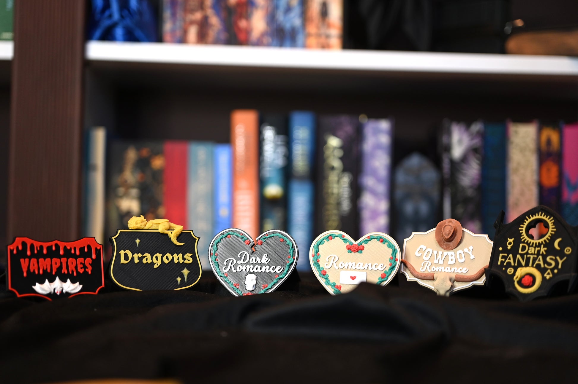 Set de plăcuțe decorative 3D pentru bibliotecă in Raft cu cărți ilustrate în stil fantasy și romance, organizate cu etichete 3D tematice pentru Romance, Dark Romance, Cowboy Romance și Vampires.”