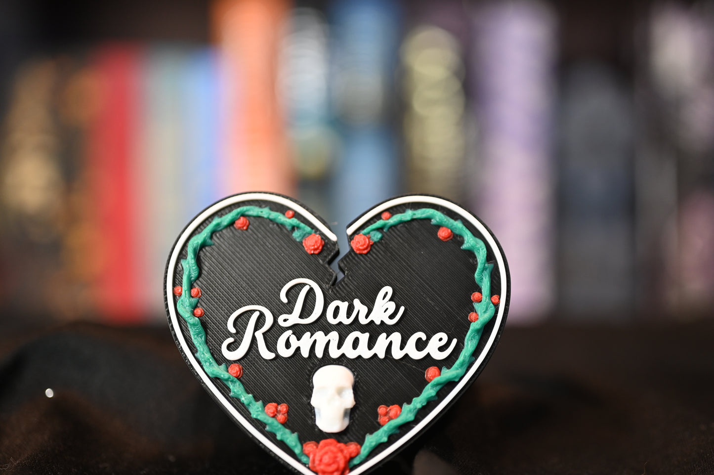 Etichetă 3D în formă de inimă neagră pentru secțiunea Dark Romance, decorată cu trandafiri roșii, viță verde și un mic craniu alb în partea de jos.