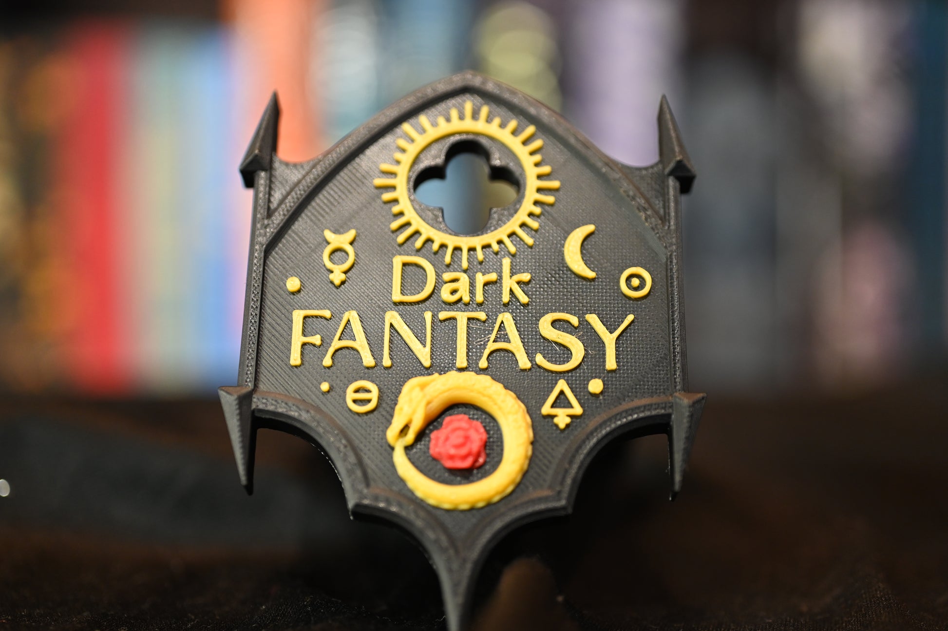 Etichetă 3D Dark Fantasy în stil gotic negru cu detalii aurii și simboluri magice, prevăzută cu două moduri de prindere: agățată pe raft sau montată cu suport adeziv.