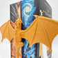 Accesoriu Decorativ Fantasy - dragon auriu care se aseaza intre carti, parand ca le imbratiseaza