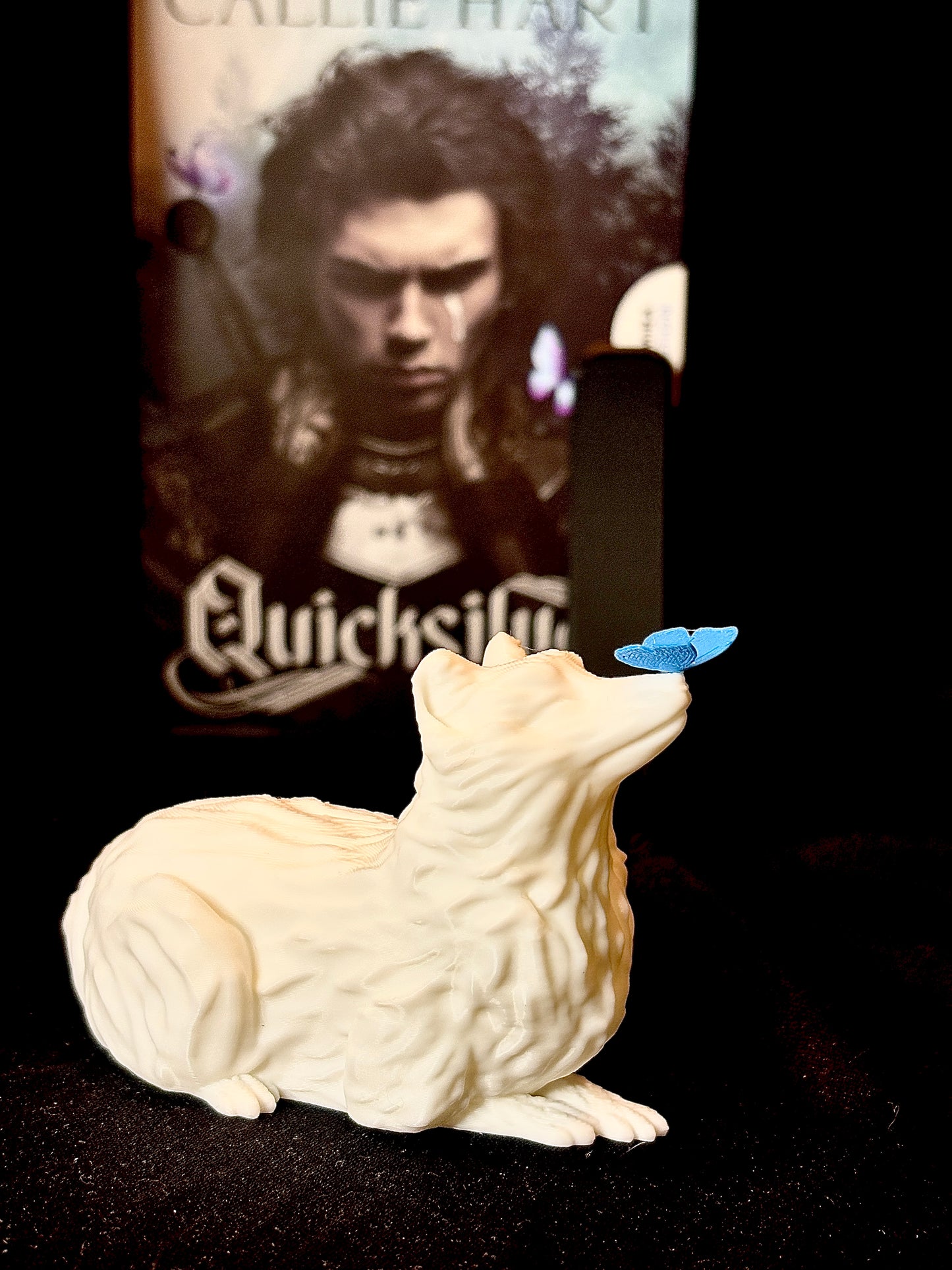 Figurină 3D Vulpița Onyx Decor 3D fantasy: vulpe albă cu fluture albastru, fotografiată lângă romanul Quicksilver.