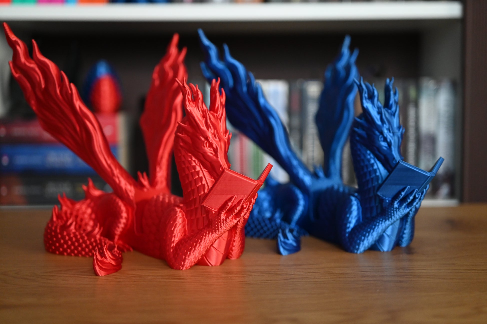 doua suporturi de kindle cu forma de dragoni, albastru si rosu