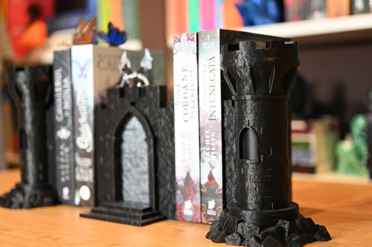 Bookend castel, cu detalii gotice și dragon, perfect pentru romane fantasy, asezat intre cartile scrise de Rachel Gillig