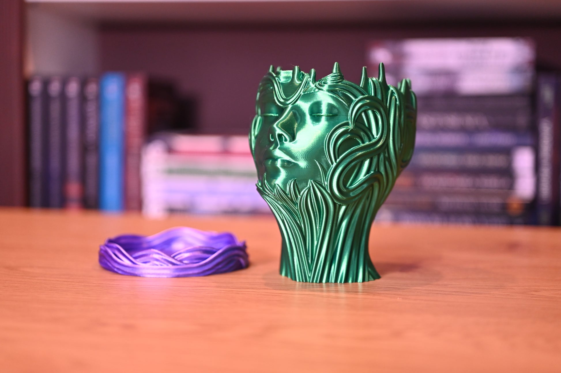 sculptura cu chiul unei femei de culoare verde smarald asezat pe un raft de lemn