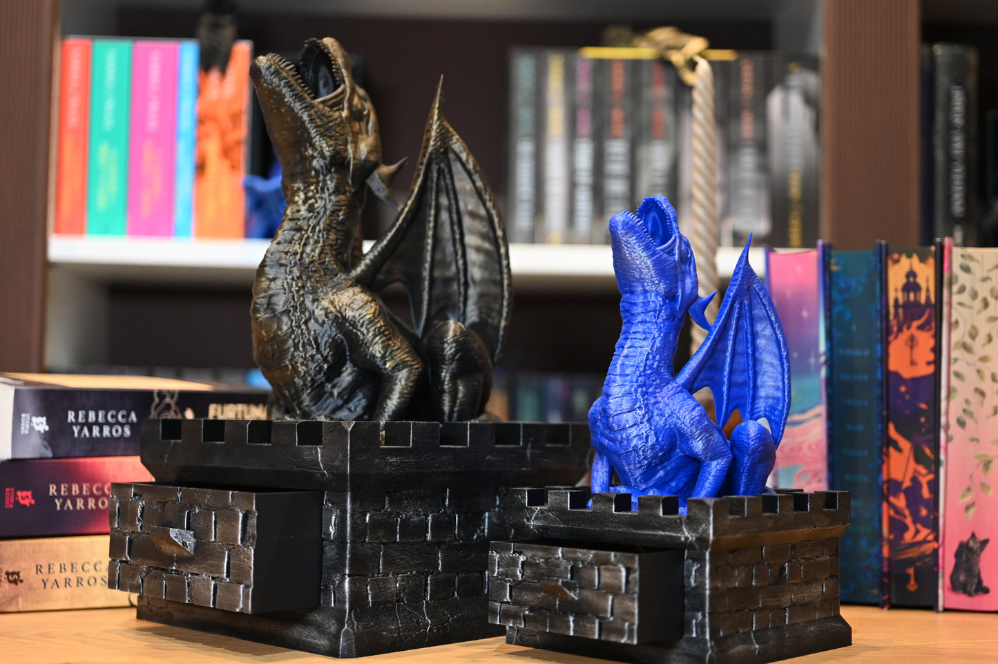 Turnul dragonului - dice tower  doua obiecte printate 3d cu doi dragoni, unul mare si auriu, celalalt mai mic si albastru, care stau pe zidurile unui castel ce formeaza cutii de depozitare pentru zaruri dungeons and dragons sau pentru semne de carte