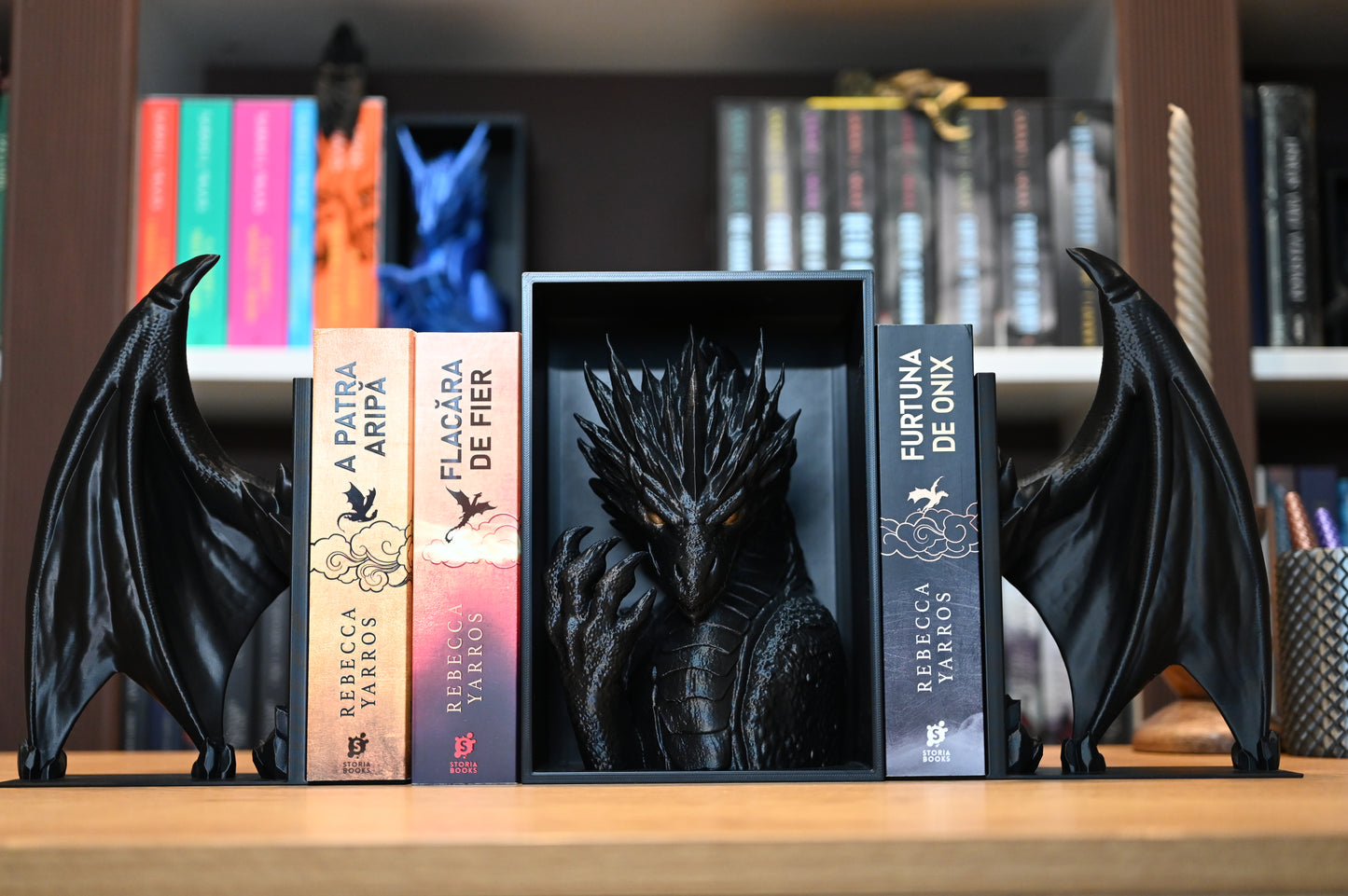 Figurină dragon 3D integrată într-un suport de cărți, alături de titluri fantasy populare