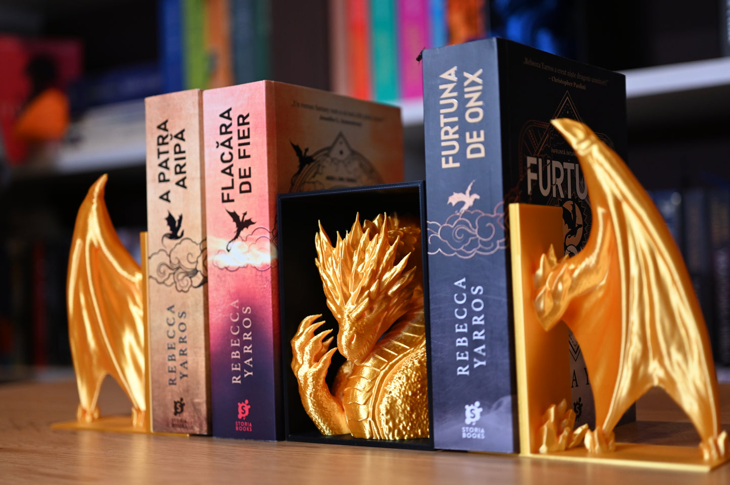 Suport de cărți artistic cu dragon, cu aripi bookends, pe un raft de bibliotecă plin de romane scrise de Rebecca Yarros