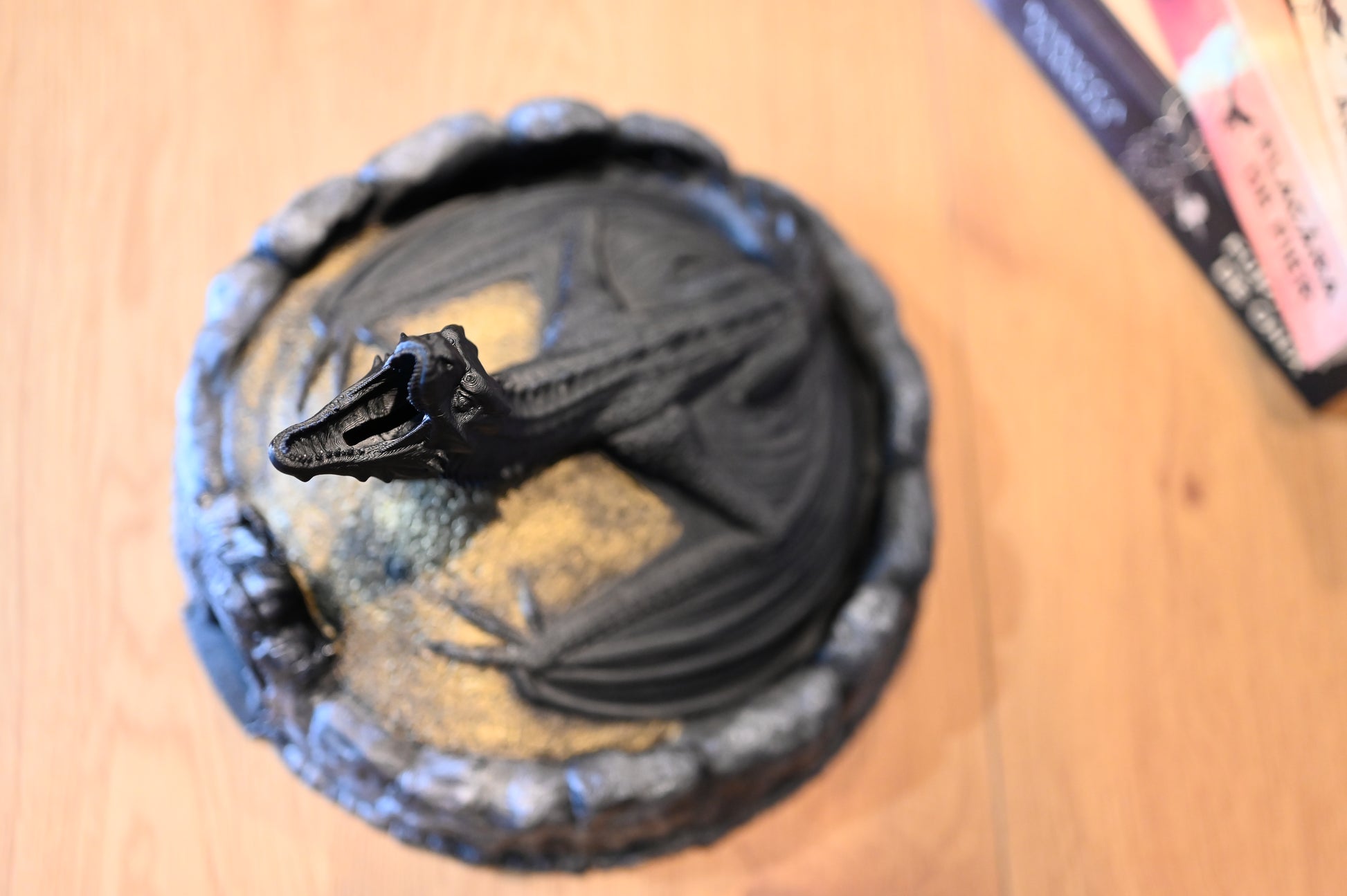 Vedere de sus a unei figurine cu dragon negru pe un munte auriu, cu gura deschisă, pentru a se vedea insertul de monede, stil decor fantasy
