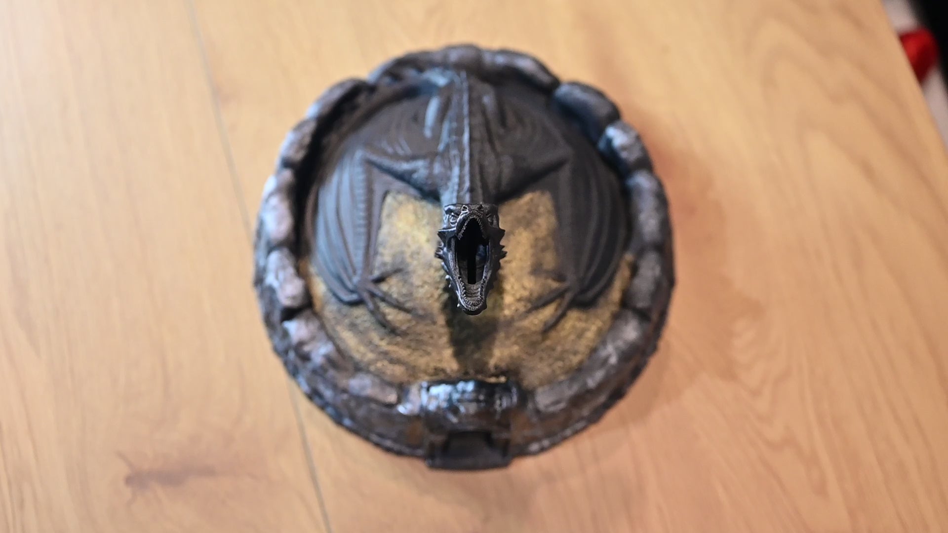 Figurină decorativă cu dragon negru pe un munte auriu folosit ca pusculita 