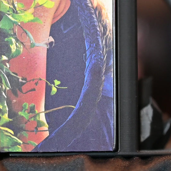 Cartea „Flacăra de fier” de Rebecca Yarros, ediție specială realizată de Printedges, prezentată între suporturi negre în formă de dragoni. Marginea imprimată (printed edge) arată portretul unei tinere înarmate și capul unui dragon negru cu ochi galbeni, ilustrând perfect universul fantasy al seriei Empyrean.